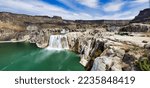 Shoshone Falls Reservoir in Twin Falls, Idaho. Wide angle view of the water flowing over the stone cliffs with a view of the dam and table rocks in the background. 