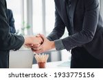 Business man in a suit shakes hands to agree a business partnership agreement. Business etiquette concept of congratulation, concept of handshake during office meeting.