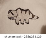 Small photo of Hand made embroidery from a bison called appa from animated show Avatar the last airbender on a beige piece of clothing or pullover or hoodie. Hand crafted art with split stitch long and short stitch