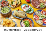 Small photo of Mexican festive food for independence day - independencia chiles en nogada, tacos al pastor, chalupas pozole, tamales, chicken with mole poblano sauce. Yellow background