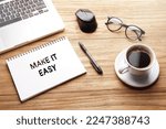 Small photo of Make It Easy, motivational words and sentences for work and life. Quote sentence in notebook with laptop, pen, coffee over wooden background.