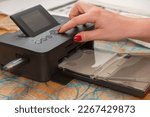 Small photo of on portable inkjet photo prints - closeup woman hand operated printer