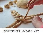 Person in braiding brioche - closeup braid of  yeast dough cake