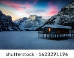 Dawn with a purple sky over the frozen Lago di Braies, or Pragser Wildsee, during winter time without people