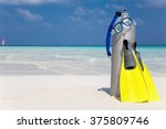 Scuba diving tank, fins and mask on a beach
