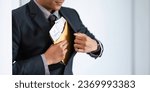 Small photo of Businessman briefcase document envelope with dollar banknotes on white background. businessman putting illegal secret agreement money in his jacket. corruption, bribery, crime and embezzle concept