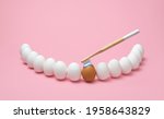 Small photo of Concept for oral hygiene with a wooden toothbrush, toothpaste, and several eggs simulating the human teeth. Brushing teeth with a wooden toothbrush.