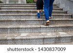Small photo of Close up of legs Asian mother and her daughter Walking up the wet ladder and without warning signs in the park. Dangerous for people.