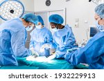 Small photo of Surgical team performing surgery in modern operation theater,Team of doctors concentrating on a patient during a surgery,Team of doctors working together during a surgery in operating room