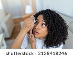 Small photo of Woman using eye drop, woman dropping eye lubricant to treat dry eye or allergy, sick woman treating eyeball irritation or inflammation woman suffering from irritated eye, optical symptoms