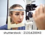 Small photo of Attentive optometrist examining female patient on slit lamp in ophthalmology clinic. Young beautiful woman is diagnosed with eye pressure on special ophthalmological equipment.