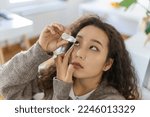 Small photo of Asian Woman using eye drop, woman dropping eye lubricant to treat dry eye or allergy, sick woman treating eyeball irritation or inflammation woman suffering from irritated eye, optical symptoms