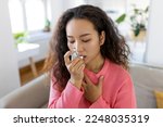 Asian woman using inhaler while suffering from asthma at home. Young woman using asthma inhaler. Close-up of a young Asian woman using asthma inhaler at home.