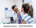 Small photo of Doctor using inspection spatula to examine patient throat. ENT doctor doing throat exam of a woman. patient opened her mouth to throat check-up