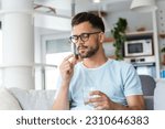 Small photo of Young man takes medication prescribed by his physician. Man taking a pill and drinking a glass of water. Health, medicine, treatment concept