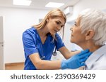 Small photo of Endocrinologist examining throat of senior woman in clinic. Women with thyroid gland test . Endocrinology, hormones and treatment. Inflammation of the sore throat
