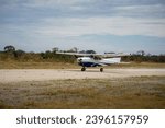 Cessna propeller plane takes off on a gravel runway or airstrip in the Okavango Delta in Botswana, Africa