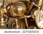 Small photo of Macrophotography of thumbtacks, thumbtacks, metallic piled up, showing details of small welds and grooves. Predominant golden color.