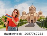 Small photo of Woman traveler with Armenian flag at the Saint Gregory The Illuminator Cathedral. Sightseeing and tourism in Yerevan.