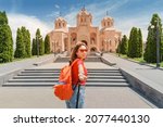 Small photo of Follow me to the tourist attractions of Yerevan and Armenia. Woman traveler with backpack at to the entrance to Saint Gregory The Illuminator Cathedral.