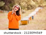 Small photo of Screaming woman was attacked by an aggressive and dangerous swarm of killer bees in a honey apiary. The concept of allergy and first aid after being stung by insect venom.