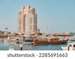Small photo of 15 January 2023, Abu Dhabi, UAE: Rixos Marina majestic palace hotel view from port, with cruise boats and ships in foreground