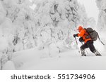 skitour or backcountry skier in the woods with a backpack hiking in winter