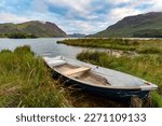 Small photo of A moored rowing boat at Nether How, Crummock Water, with Mellbreak Fell in the distance, Lake District National Park.