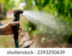 Hand seen holding a hose that...