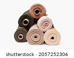 Stack of pastel color fabric rolls isolated on white, Synthetic and natural fabrics with copyspace