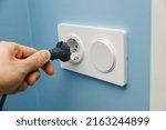 Small photo of Inserting power cord receptacle in wall outlet