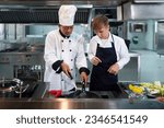 Small photo of Chef teacher teaches cooking to the group children in class kitchen room. Chef preparing student for learning marking and cooking food at workshop. Education Concept