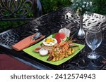 Small photo of shrimps on plate with rice, lemon, salt, sauce and eag. Top view. Big red prawns for lunch on rustic stone background. Healthy clean eating. Shrimps close-up.