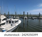 Small photo of Murrells Inlet South Carolina USA-August 23, 2023. Various styles of boats dock docked at the Crazy Sister Marina along the Marsh Walk.