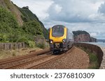 Small photo of A passenger train en route to nearby Teignmouth and beyond, here passing close to the walkway on the atmospheric line following the coastline through Devon UK