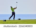 Small photo of Golfer on a golf course, ready to tee off. Golfer with golf club hitting the ball for the perfect shot.