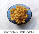 Small photo of Lanthing is a traditional Indonesian snack made from cassava that has been crushed, seasoned, and subsequently fried. Pile of lanting in a blue bowl isolated in white cloth background.