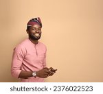 Small photo of An excited overjoyed black man holding a smartphone receives news from mobile online bet bid game win, happy ecstatic African guy looking at his cell phone celebrates receiving reading good news.
