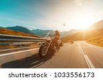 Motorcycle driver riding japanese high power cruiser in Alpine highway on famous Hochalpenstrasse, Austria, central Europe.