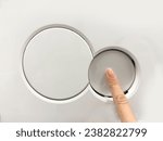 Small photo of A hand flushes the toilet. Close-up of checking the toilet flush button in a store. Selecting a button to flush the toilet. High quality photo