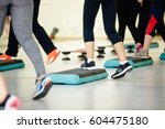 Small photo of Women doing aerobic class with steppers to people group on fitness center detail of raised feet during aerobic step exercise at gym aerobics and people concept people working out with steppers in gym.