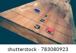 Small photo of Vintage shuffle board game with red and blue disc on wooden shuffle table. Shuffleboard table game with selective focus.