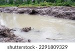 Small photo of Turbid Water River Flow, With Muddy Soil Texture, In Belo Laut Village During The Day