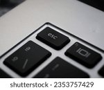Black esc button escape close up on a laptop keyboard 
