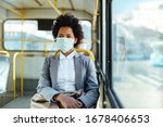 African American businesswoman wearing protective mask while traveling by public transportation. 