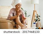 Young beautiful woman painting her toenails at home. 