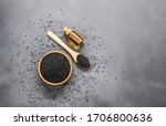 Small photo of glass bottle of black cumin seeds essential oil , Nigella Sativa in spoon on rustic table. Organic herbal medicine for many diseases, black cumin