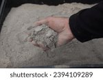 Small photo of a handful of ashes to use in the garden. man holding a pile of wood ashes