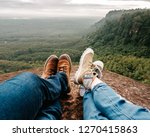 Small photo of trekking shoes on feet of couple of travelers hikers sitting on top of the mountain in bung karn with the beautiful view, Bung karn in Thailand