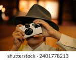 Small photo of close up of child with vintage throwaway film camera at wedding